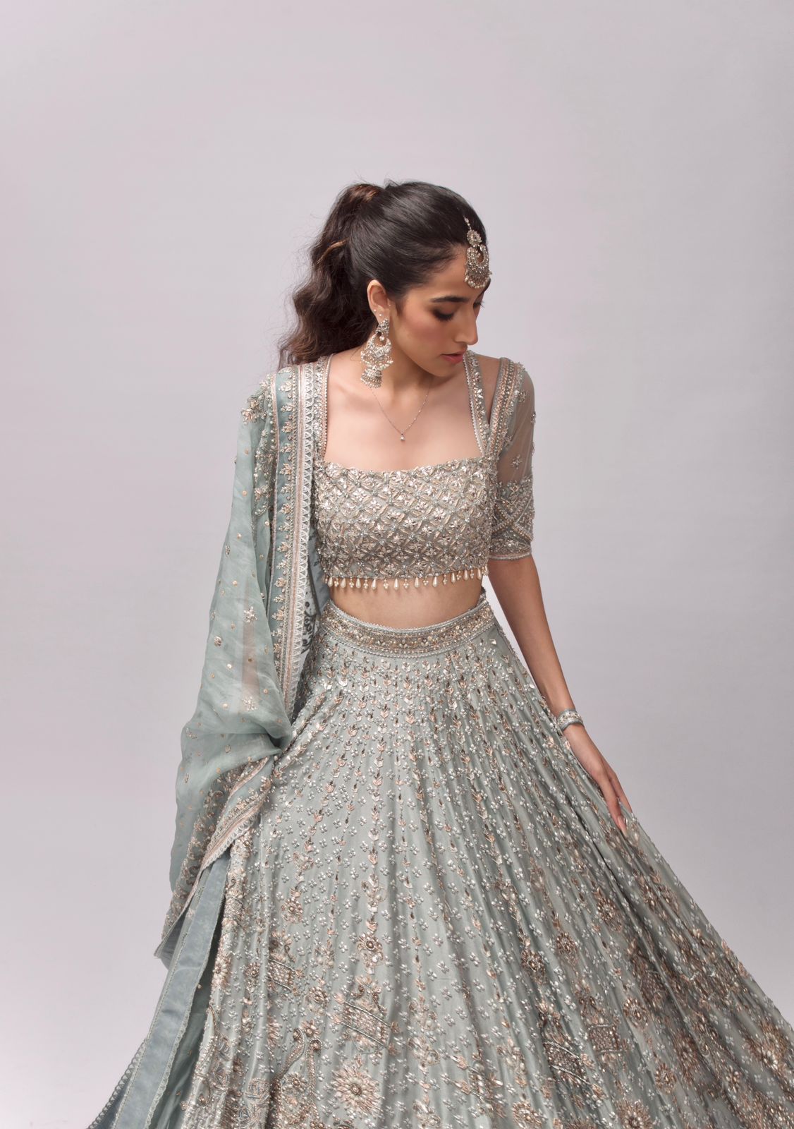 SILVER GREY SHIMMERY LEHENGA SET WITH A HAND EMBROIDERED BLOUSE PAIRED WITH  A RUFFLED DUPATTA AND SILVER EMBELLISHMENTS. - Seasons India